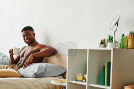 Photo for Cheerful shirtless african american man with coffee cup looking away on cozy bed at home, morning - Royalty Free Image