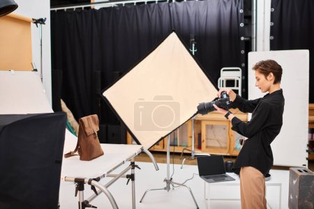 beautiful talented female photographer taking photos of brown leathered backpack in her studio