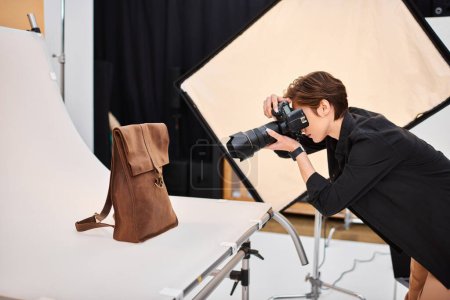 hermosa fotógrafa de pelo corto tomando fotos de mochila de cuero marrón en su estudio