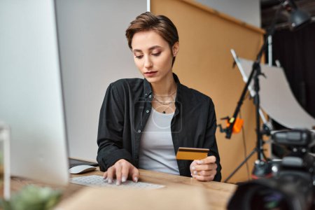charmante jeune photographe féminine en tenue décontractée confortable payer en ligne avec sa carte de crédit