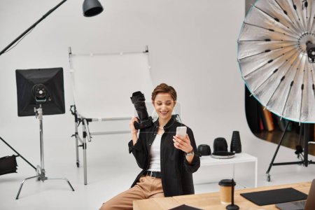 Téléchargez les photos : Joyeux jolie photographe en tenue décontractée faire des histoires pour ses médias sociaux dans son studio - en image libre de droit