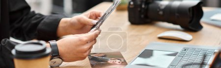 Photo for Cropped view of young female photographer holding photos in hands while sitting at table, banner - Royalty Free Image