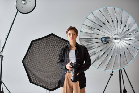 Foto de Joven fotógrafa guapa con atuendo casual mirando la cámara mientras está en su estudio - Imagen libre de derechos