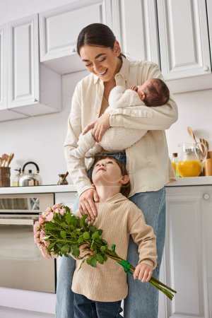 loving joyful family in housewear posing with flower bouquet while on kitchen, modern parenting