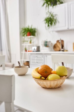Objektfoto einer modernen Küche mit frischen Früchten auf dem Tisch und verschwommenen Pflanzen auf dem Hintergrund