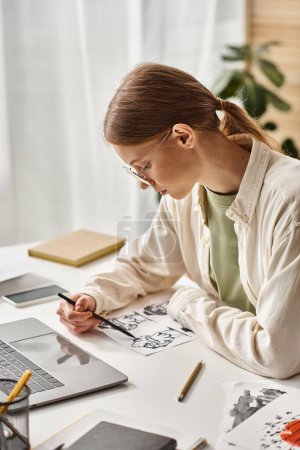 young teenage girl drawing with pencil near laptop at home, e-learning and art class concept