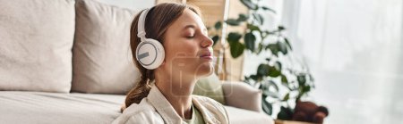 carefree teenage girl in her wireless headphones listening music and holding cup of tea, banner
