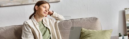 banner of dreamy teenage girl sitting with her laptop on a sofa at home, e-learning concept