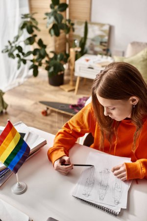 vista aérea de una adolescente pensativa dibujando un boceto, inmersa en un proceso creativo con bandera de orgullo