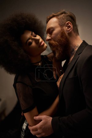 chic curly african american woman in dress seducing tattooed boyfriend with beard, date night