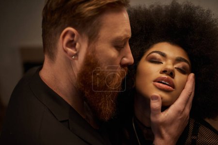 bärtiger Mann verführt hübsche Afroamerikanerin mit lockigem Haar, intimer Moment eines sexy Paares