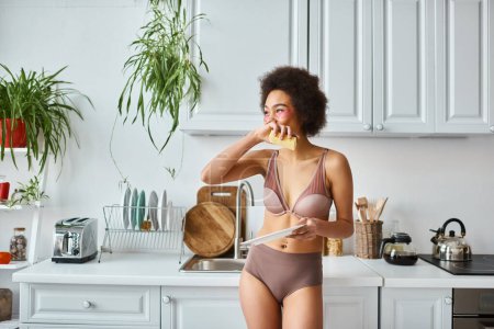 african american woman in lingerie with pink patches under eyes washing plate with sponge, laugh