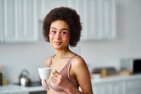Téléchargez les photos : Jolie femme afro-américaine avec des patchs debout en sous-vêtements et profiter du café dans la tasse - en image libre de droit