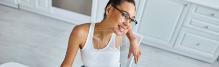 Photo for Top view of happy african american woman in glasses and tank top smiling at home, horizontal banner - Royalty Free Image