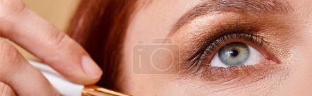 close up banner, redhead woman applying sparkling glitter on cheek with makeup brush on beige