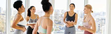 Photo for Group of five happy multicultural women in sportwear and chatting before pilates class, banner - Royalty Free Image