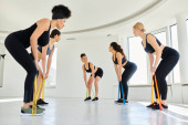young diverse women looking at happy pilates instructor and working out with resistance bands Stickers #693842588