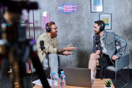 gut aussehender Interviewer und sein Gast mit Kopfhörern im Studio diskutieren Fragen, Podcast