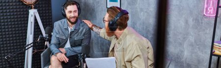 Photo for Hard working bearded interviewer discussing main questions with his guest during podcast, banner - Royalty Free Image