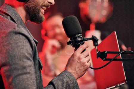 Photo for Cropped focused view of bearded man with microphone with his blurred interviewer on podcast - Royalty Free Image