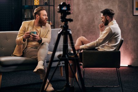 hombres dedicados con barbas en trajes elegantes sentados y discutiendo preguntas durante la entrevista