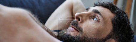 Photo for Depressed man in casual attire lying on sofa during breakdown, mental health awareness - Royalty Free Image