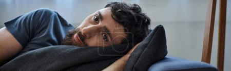 Foto de Hombre deprimido en traje casual acostado en el sofá durante la ruptura, conciencia de salud mental, pancarta - Imagen libre de derechos