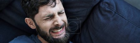 Foto de Hombre ansioso con barba en ropa casual que sufre durante la ruptura, conciencia de salud mental, bandera - Imagen libre de derechos