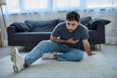 bearded suffering man in casual home wear having severe panic attack, mental health awareness puzzle #694538394