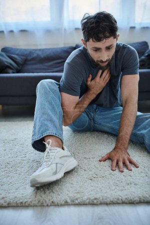 depressed traumatized man with beard in home wear having panic attack, mental health awareness