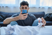 depressed suffering man looking at his smartphone during depressive episode, mental health puzzle #694538698