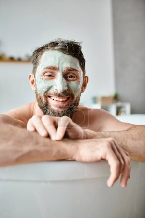 joyful attractive man with beard and face mask chilling in his bathtub, mental health awareness