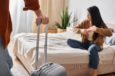 depressed asian woman taking off wedding near husband with suitcase leaving home, family divorce