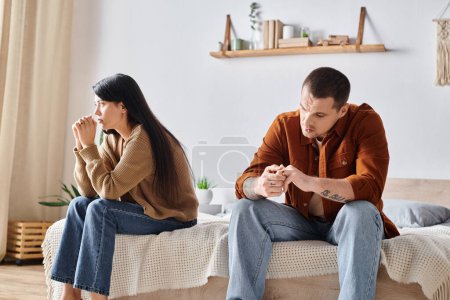 Téléchargez les photos : Couple multiethnique déprimé assis dans la chambre à coucher à la maison, concept de difficultés relationnelles - en image libre de droit