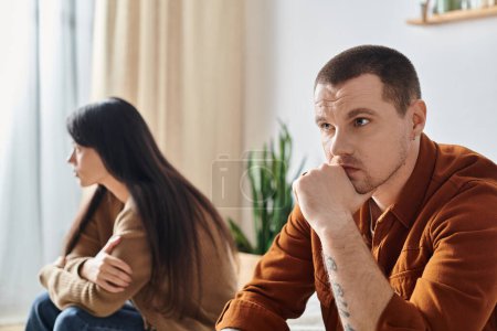 frustrierte junge interrassische Paar sitzt im Schlafzimmer zu Hause, Beziehungsschwierigkeiten Konzept