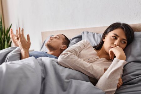 Téléchargez les photos : Jeune déprimé asiatique femme couché sur lit près querelle mari, relation conflit - en image libre de droit