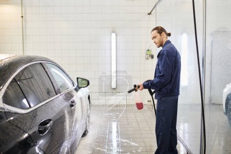 attractive dedicated specialist in blue uniform with collected hair using soap to wash car