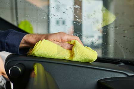 Ausgeschnittene Ansicht von engagierten Servicekräften in Uniform, die aufmerksam das Handschuhfach des Autos reinigen