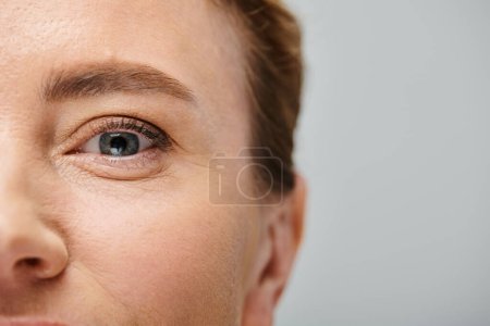 close up of beautiful woman with blonde hair looking at camera with contact lense on her eye