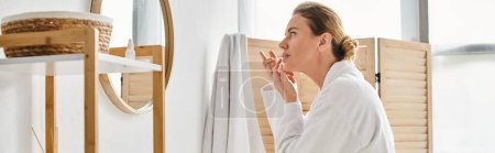 attraktive Frau im weißen bequemen Bademantel mit Kontaktlinsen in der Nähe von Spiegel im Badezimmer, Banner