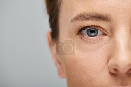 close up of appealing woman with blonde hair looking at camera with contact lense on her eye