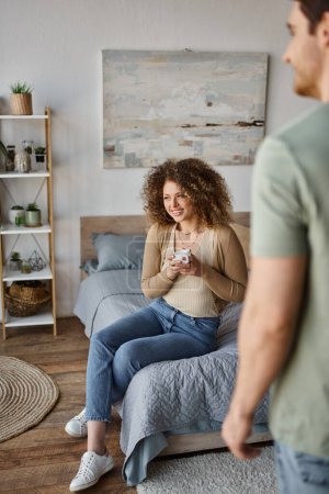 curly young woman smiling woman looking at away happily, morning couple time at bedroom, banner