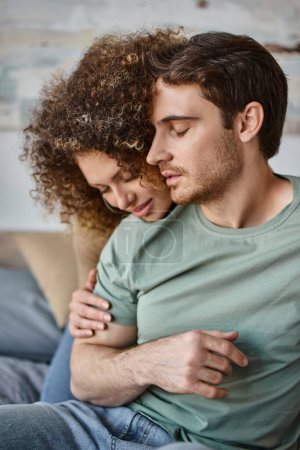 Photo for Curly young woman and brunette man savor a warm hug, cherishing the quiet moment - Royalty Free Image