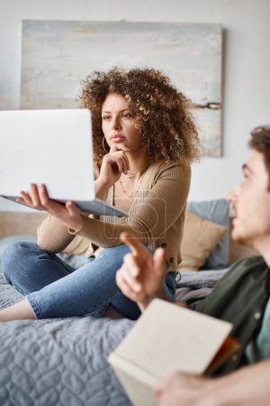 daily routine of couple, concerned woman looking at laptop screen while listening to her boyfriend