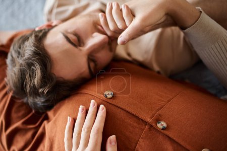 Tender moment. Pregnant woman with husband lying in bed, man resting near belly of wife