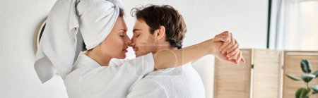 Glückliches Paar in Bademänteln, das sich verliebt kuschelt im Badezimmer, Frau mit Handtuch auf dem Kopf, Banner