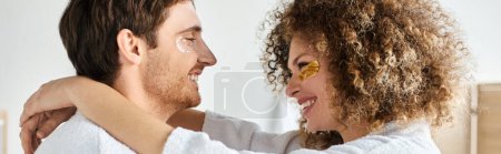 Portrait of happy couple with eye patches  in bathroom and smiling, looking at each other, banner