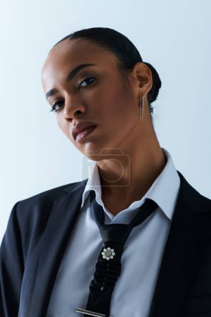 Foto de Una joven afroamericana con corbata negra y camisa blanca emana sofisticación y estilo - Imagen libre de derechos