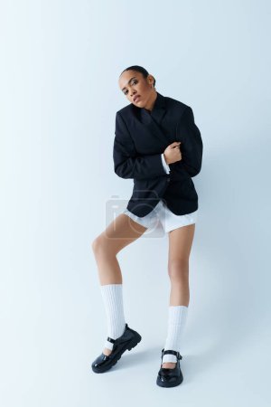 Young woman models with striking confidence posing in a black blazer