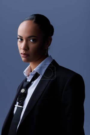 A stylish young African American woman confidently posing in a suit and tie.